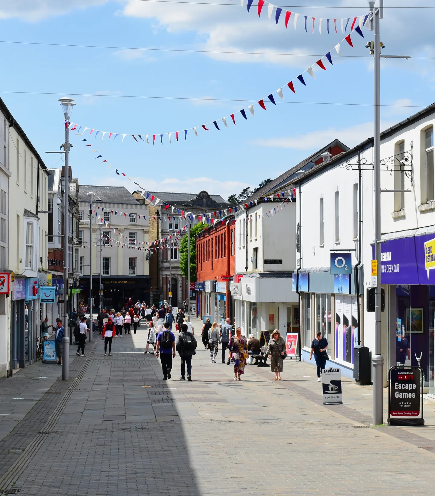 Shoppers and bunting on the pedestrianised high street in Bridgend town centre